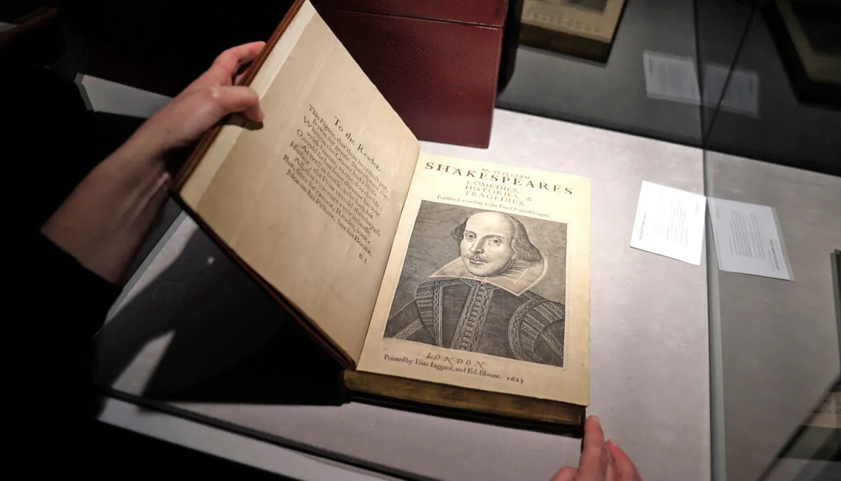 An employee of Christie's auctions holds a 1663 rare first folio of 36 Shakespeare works that was sold for a record 8.4 million dollars (9.978 million with buyers fee) in the Manhattan borough of New York City, New York, U.S., Oct. 14, 2020. REUTERS/Carlo Allegri