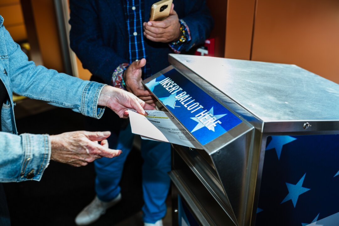 A person delivers an absentee ballot to a ballot drop box in Louisville, Ky., on Oct. 13, 2020. (Jon Cherry/Getty Images)