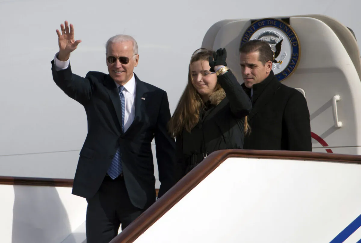 Then Vice President Joe Biden waves as he walks out of Air Force Two with his granddaughter, Finnegan Biden (C) and son Hunter Biden (R) upon their arrival in Beijing on Dec. 4, 2013. (Ng Han Guan/AFP via Getty Images)
