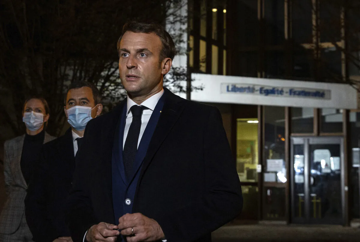 French President Emmanuel Macron, flanked by French Interior Minister Gerald Darmanin, second left, speaks in front of a high school in Conflans Sainte-Honorine, on Oct.16, 2020. (Abdulmonam Eassa, Pool via AP)