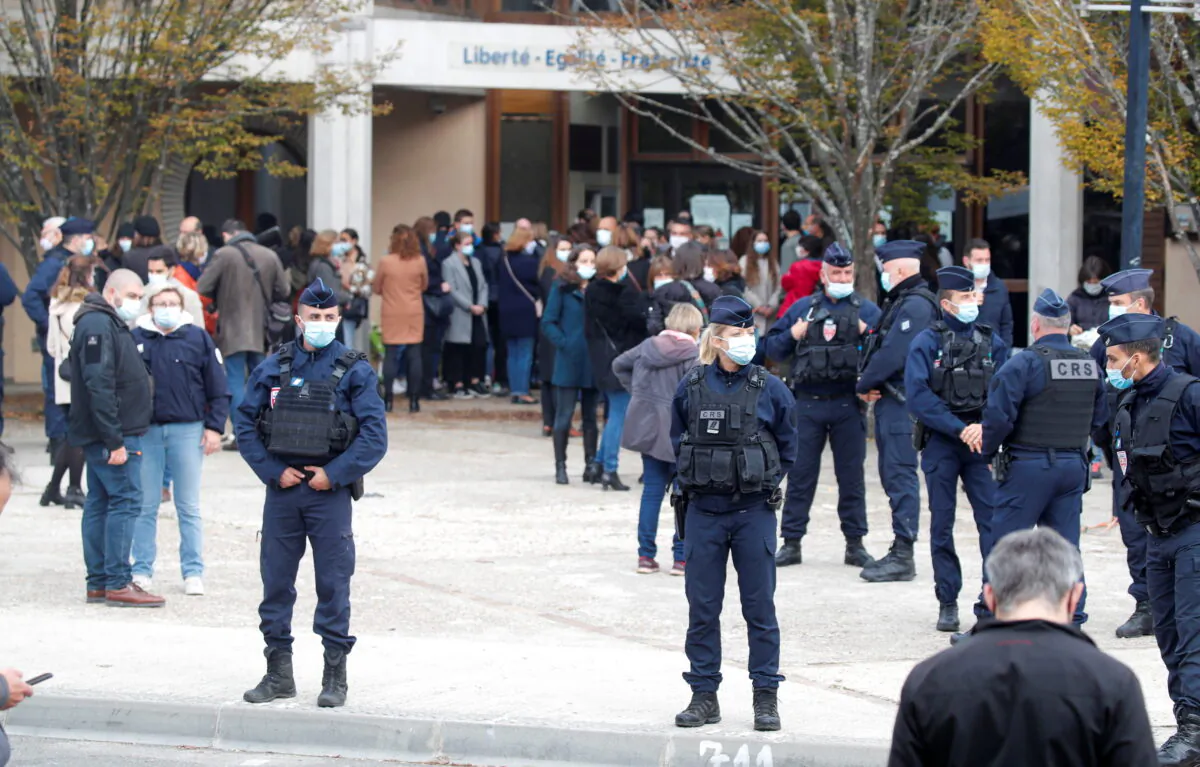 People gather in front of the Bois d'Aulne college after the attack in the Paris suburb of Conflans St Honorine, France, on Oct. 17, 2020. (Charles Platiau/Reuters)