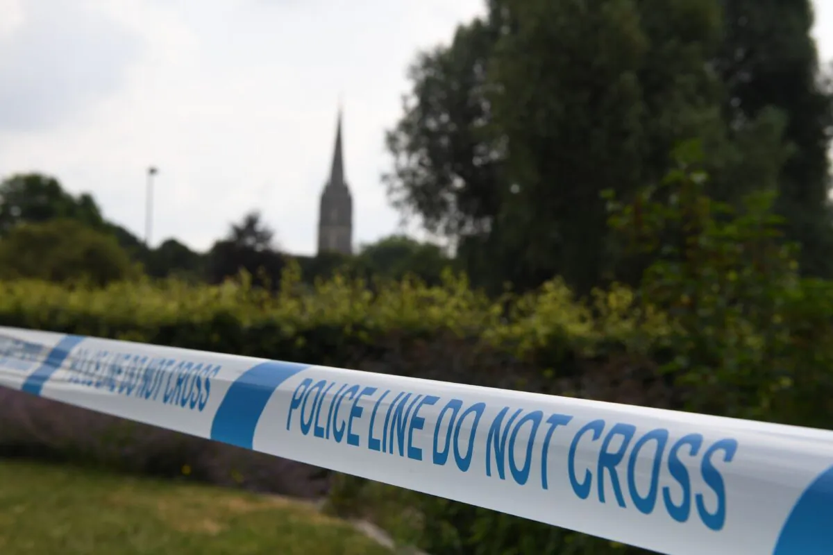 The spire of Salisbury Cathedral is seen behind police tape making a cordon around Queen Elizabeth Gardens, after former Russian spy Sergei Skripal and his daughter Yulia was poisoned, in Salisbury, southern England, on July 5, 2018. (Chris J Ratcliffe / AFP via Getty Images)