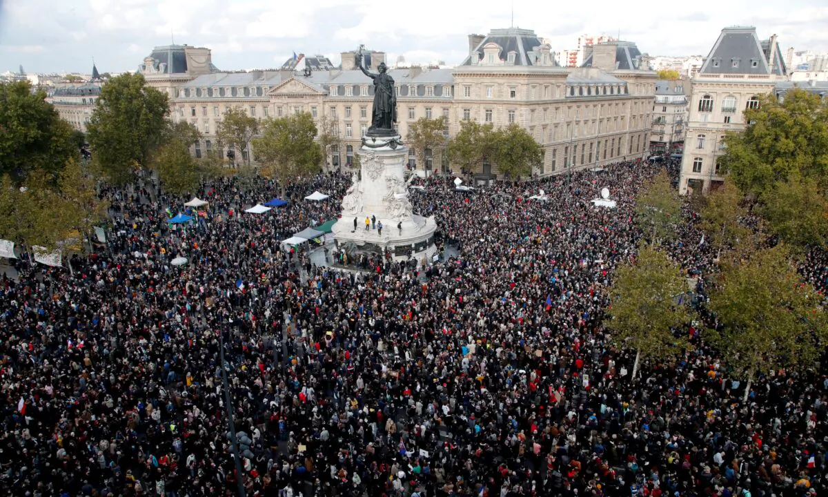 Hundreds of people gather on Republique square during a demonstration in Paris on Oct. 18, 2020. Demonstrations around France have been called in support of freedom of speech and to pay tribute to a French history teacher who was beheaded near Paris after discussing caricatures of Islam's Prophet Muhammad with his class. Samuel Paty was beheaded on Friday by a 18-year-old Moscow-born Chechen refugee who was shot dead by police. (Michel Euler/AP Photo)