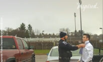 Police officer helps student tie a necktie