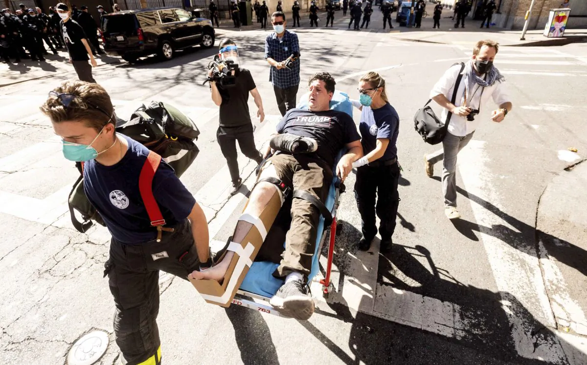 Medics transport a supporter of President Donald Trump to an ambulance after he was attacked by counter-protesters in San Francisco, Calif., on Oct. 17, 2020. (AP Photo/Noah Berger)