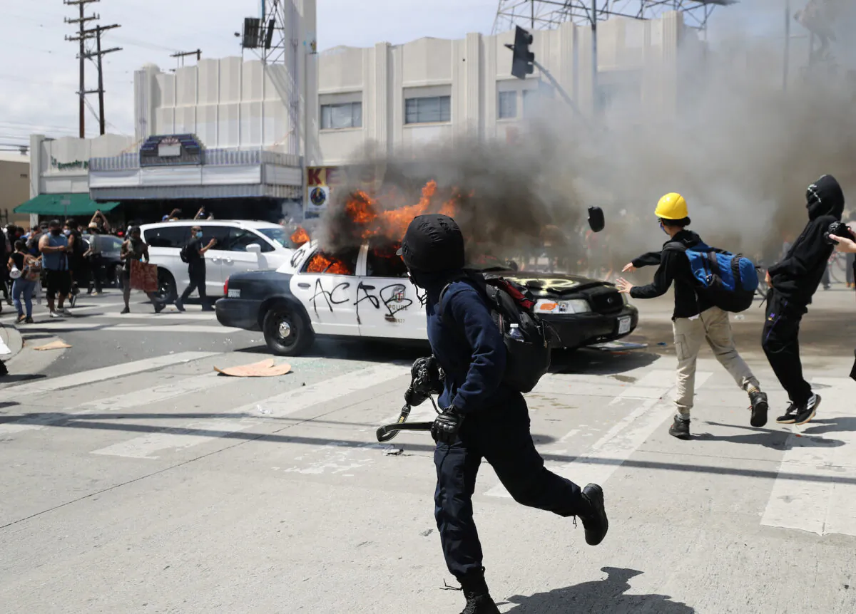 An LAPD vehicle is set on fire by rioters during a Black Lives Matter protest in Los Angeles, Calif., on May 30, 2020. (Mario Tama/Getty Images)