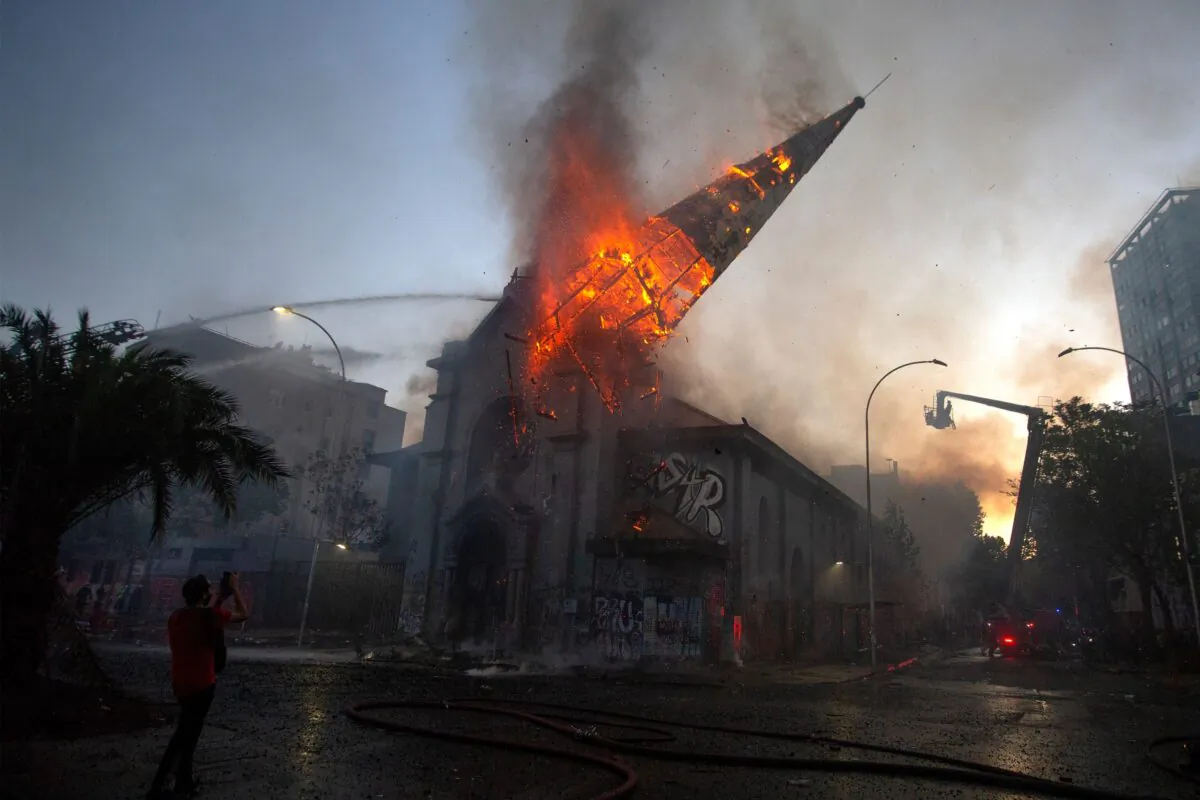The dome of the church of Asunción falls down burning in flames after being set on fire by rioters on the commemoration of the first anniversary of the social uprising in Chile, in Santiago, on Oct. 18, 2020. (Claudio Reyes/AFP via Getty Images)