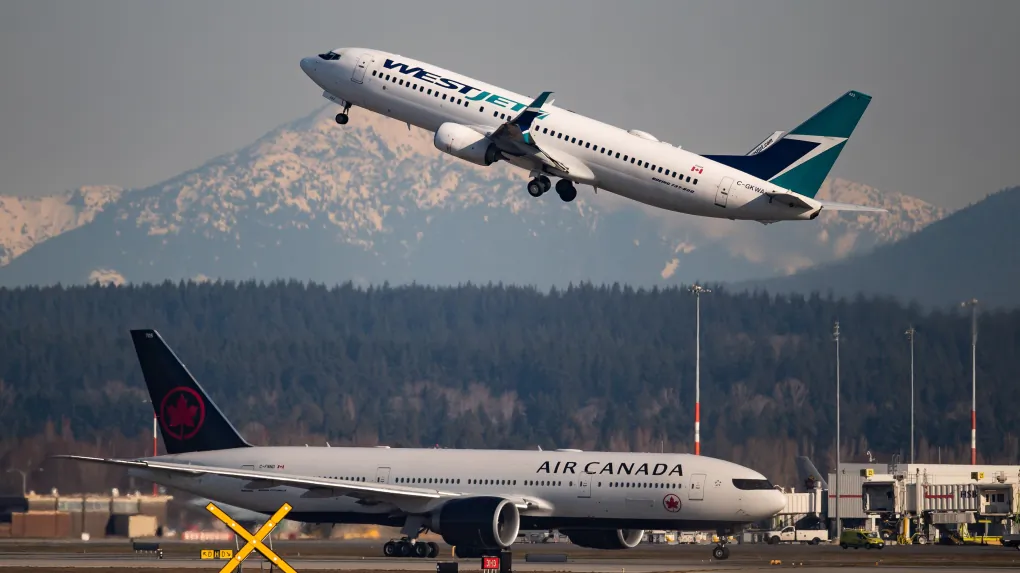 An Air Canada flight departing for Toronto, bottom, taxis to a runway as a Westjet flight bound for Palm Springs takes off at Vancouver International Airport, in Richmond, B.C. (Darryl Dyck/The Canadian Press)