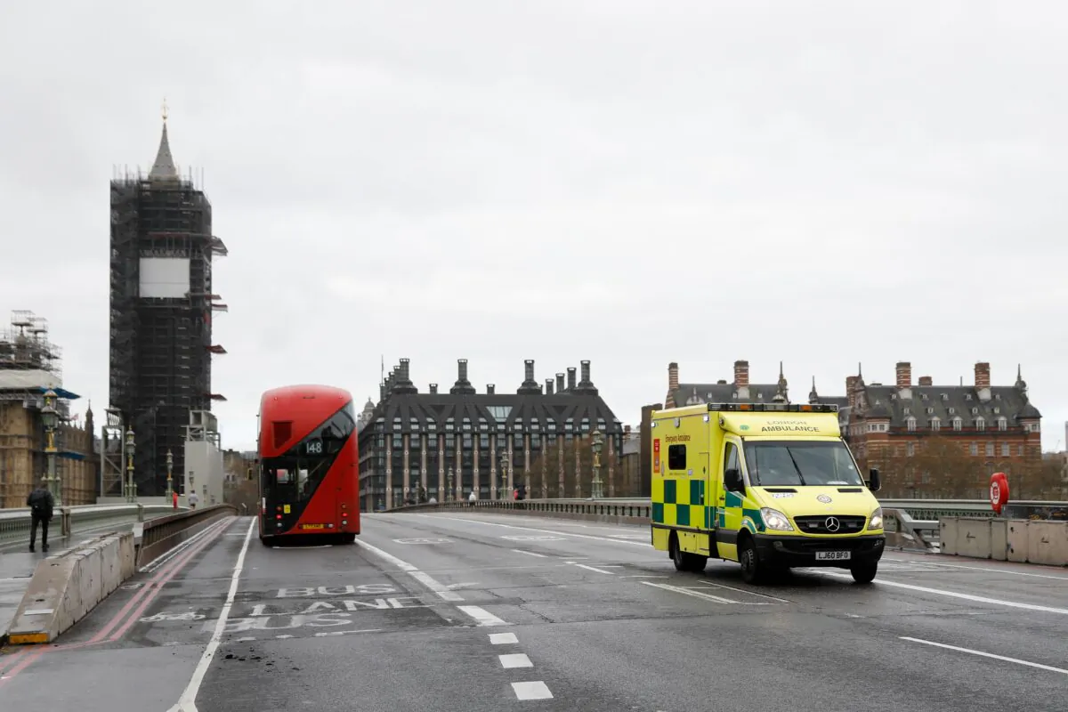 An ambulance drives over Westminster Bridge with the Houses of Parliament in the background in London on April 6, 2020. (Tolga Akmen/AFP via Getty Images)