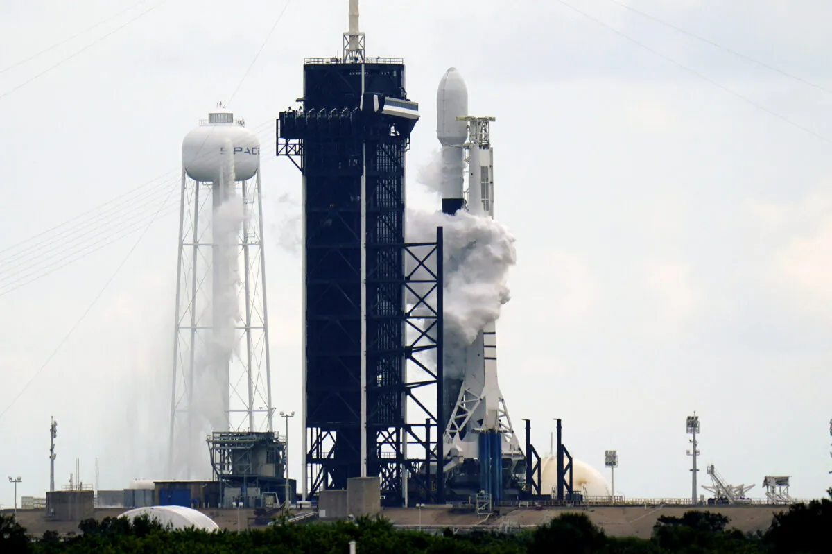 A SpaceX Falcon 9 rocket with a payload of approximately 60 satellites for SpaceX's Starlink broadband network stands on pad 39A moments before the launch was scrubbed due to weather concerns at the Kennedy Space Center in Cape Canaveral, Fla., on Sept. 28, 2020. (AP Photo/John Raoux)
