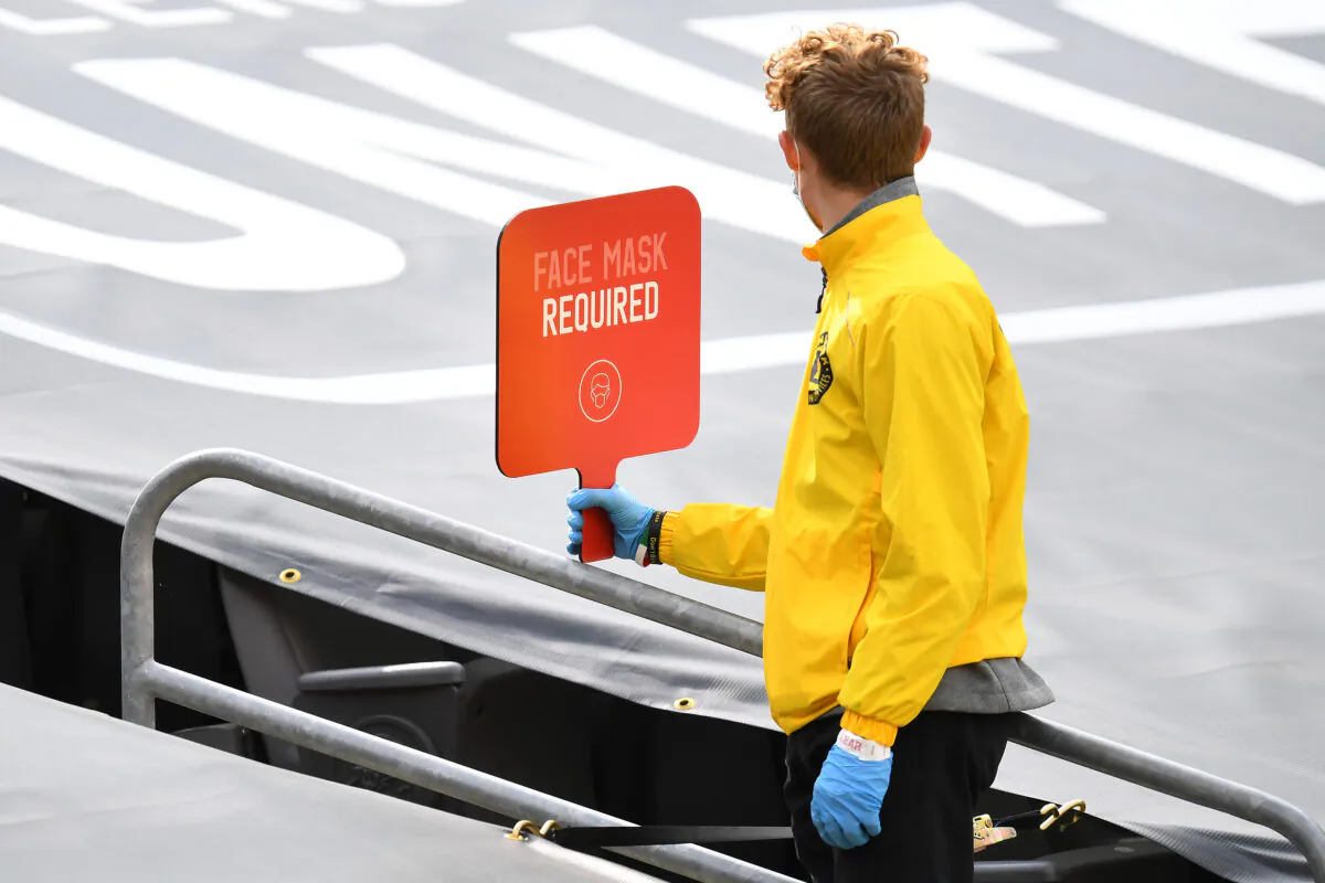 An usher holds a sign for face masks during the NFL game between the Cleveland Browns and the Pittsburgh Steelers at Heinz Field in Pittsburgh, Penn., on Oct. 18, 2020. (Joe Sargent/Getty Images)