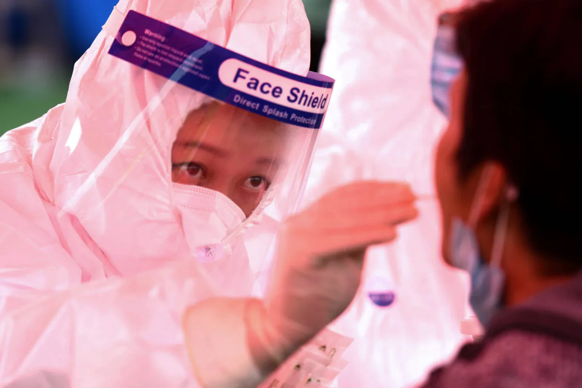 A health worker (L) takes a swab from a resident to be tested for COVID-19 as part of a mass testing program following a new outbreak in Qingdao in China's eastern Shandong Province on Oct. 14, 2020. (STR/AFP via Getty Images)