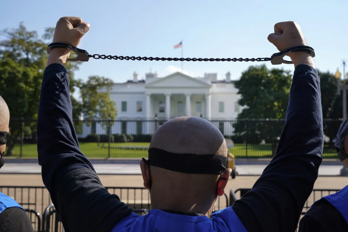 A member of the Uyghur American Association takes part in a rally in front of the White House on Oct. 1, 2020, in support of the Uyghur Forced Labor Prevention Act. The bill prohibits some imports from Xinjiang and imposes sanctions for human rights violations. The Subcommittee on International Human Rights is calling for a similar bill in Canada, as well as other measures to help end the repression of Uyghurs in Xinjiang. (AP Photo/Jacquelyn Martin)