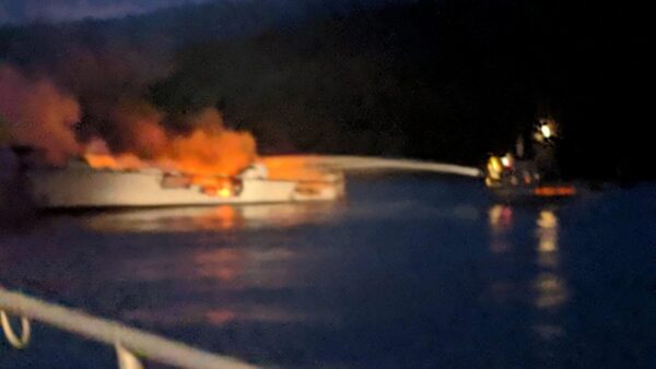 Firefighters work to extinguish a dive boat