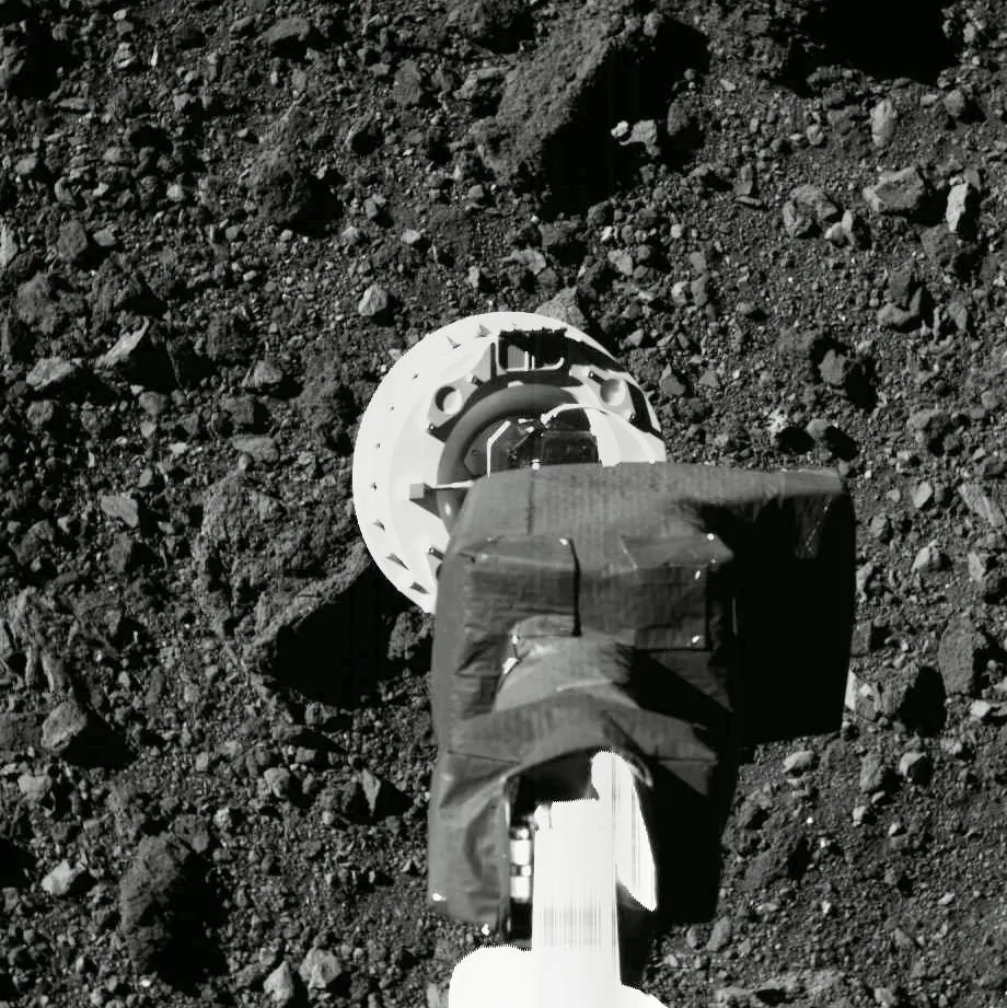 This Aug. 11, 2020 photo shows the sampling arm of the OSIRIS-REx spacecraft during a rehearsal for an approach to the "Nightingale" sample site on the surface of the asteroid Bennu. After almost two years circling the ancient asteroid, OSIRIS-REx will attempt to descend to the treacherous, boulder-packed surface and snatch a handful of rubble on Tuesday, Oct. 20, 2020. (NASA/Goddard/University of Arizona via AP)