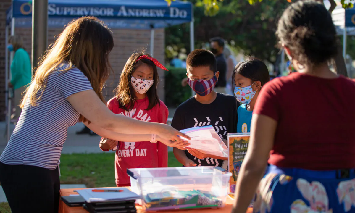 Helpful staff members provide children with information at the launch of Orange County's WiFi on Wheels program at Westminster Public Library in Westminster, Calif., on Oct. 20, 2020. (John Fredricks/The Epoch Times)