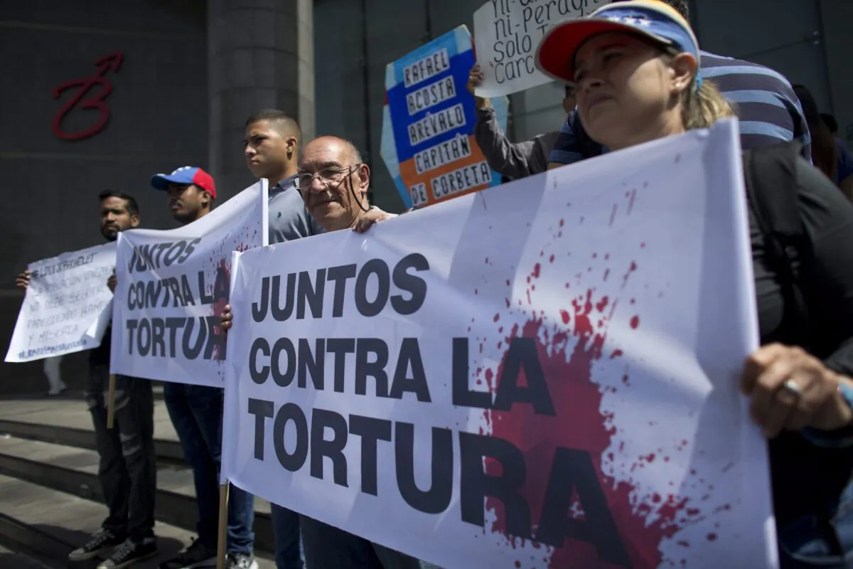 Opposition activists hold a banner that reads in Spanish "Together against torture" during a protest outside the United Nations Development Programme office in Caracas, Venezuela on July 15, 2019. (Ariana Cubillos/The Associated Press)