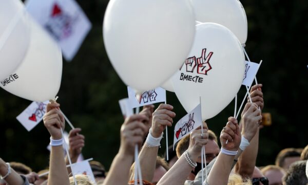 people wave white balloons