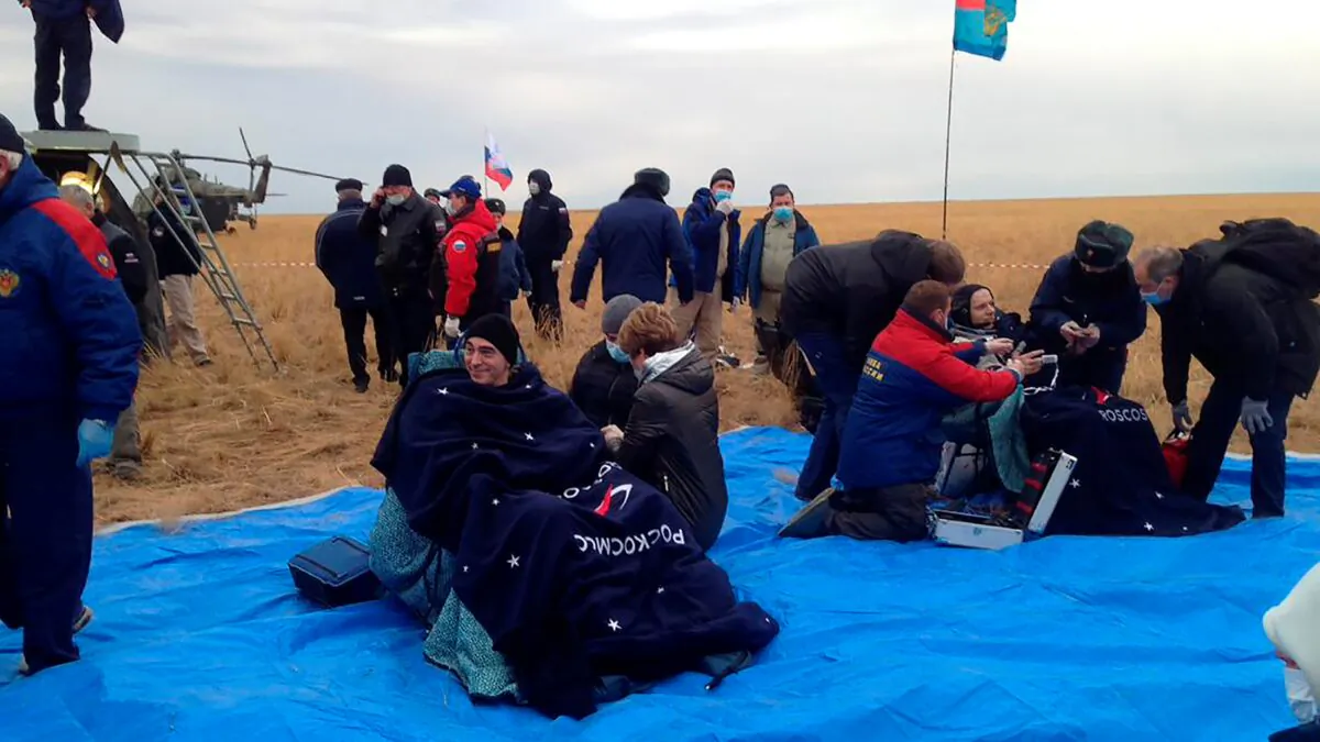 Roscosmos' cosmonauts Anatoly Ivanishin (L) and Ivan Vagner sit in chairs shortly after the landing near town of Dzhezkazgan, Kazakhstan, on Oct. 22, 2020. (Roscosmos Space Agency via AP)