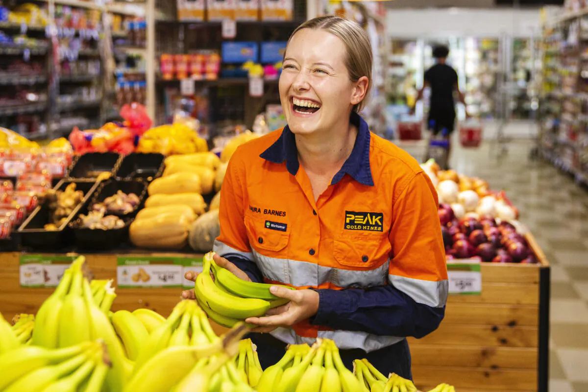 Cobar local Laura Barnes laughs as she picks bananas at Khan's Supa IGA in Cobar Australia on April 17, 2020. (Jenny Evans/Getty Images)