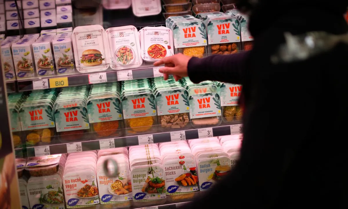 A store clerk shows plant based products at a supermarket chain in Brussels, on Oct. 23, 2020. (Francisco Seco/AP Photo)