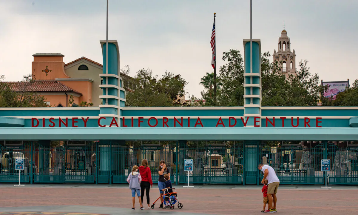 Visitors pass by the entrance to the Disney California Adventure theme park, which remains closed due to the COVID-19 pandemic, in Anaheim, Calif., on Oct. 21, 2020. (John Fredricks/The Epoch Times)