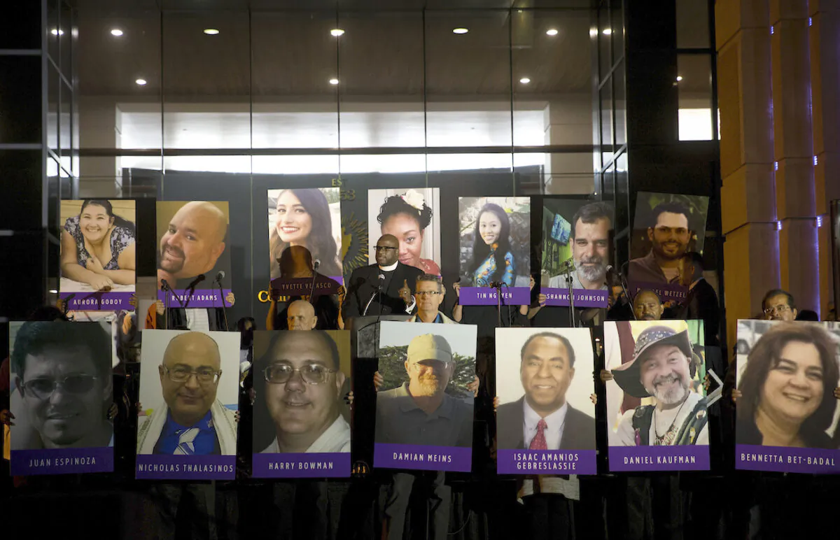 San Bernardino County employees hold up photos of the San Bernardino shooting victims during a candlelight vigil in San Bernardino, Calif., on Dec. 7, 2015. (AP Photo/Jae C. Hong, File)