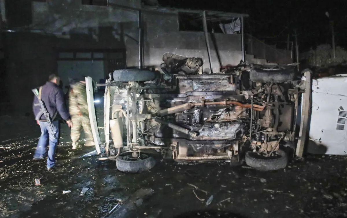 Citizens inspect a car destroyed during a shelling by Azerbaijan's artillery during a military conflict in Stepanakert, the separatist region of Nagorno-Karabakh, on Oct. 23, 2020. (AP Photo)