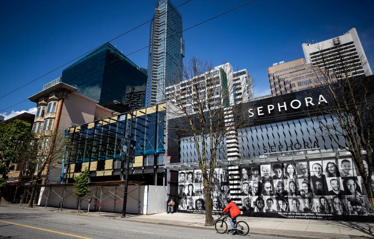 A cyclist rides past closed stores on Robson Street in Vancouver on May 6, 2020. (The Canadian Press/Darryl Dyck)