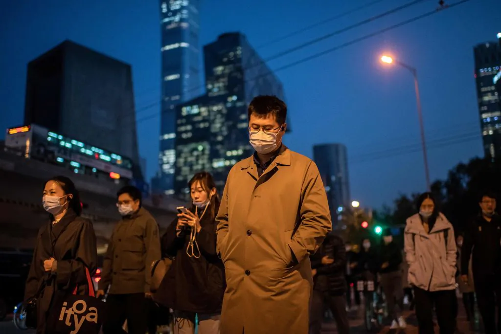 People wearing masks cross a street in Beijing on Oct. 21, 2020. (Nicolas Asfouri/AFP via Getty Images)