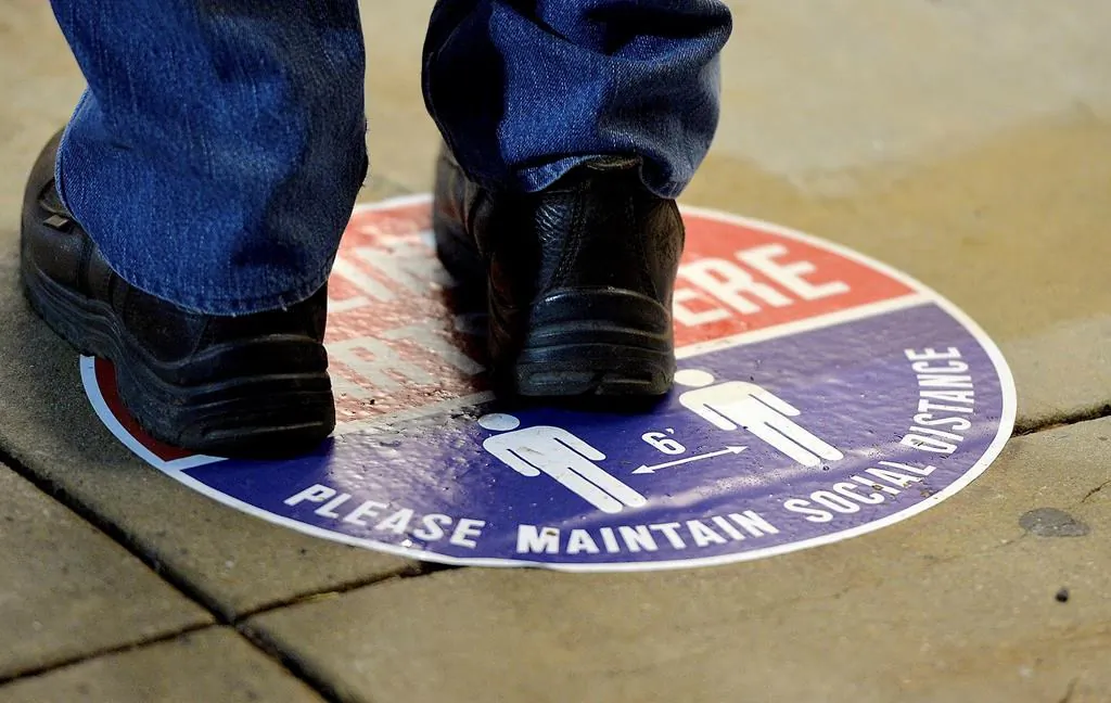 A voter stands on a social distance marker outside the Washington County Election Center in Hagerstown, Md., on  Oct. 26, 2020, for the first day of in-person early voting. (Colleen McGrath/The Herald-Mail via AP)
