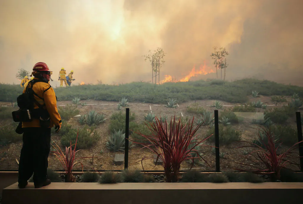A firefighter works as the Silverado Fire burns toward a home in Orange County in Irvine, Calif., on Oct. 26, 2020. (Mario Tama/Getty Images)