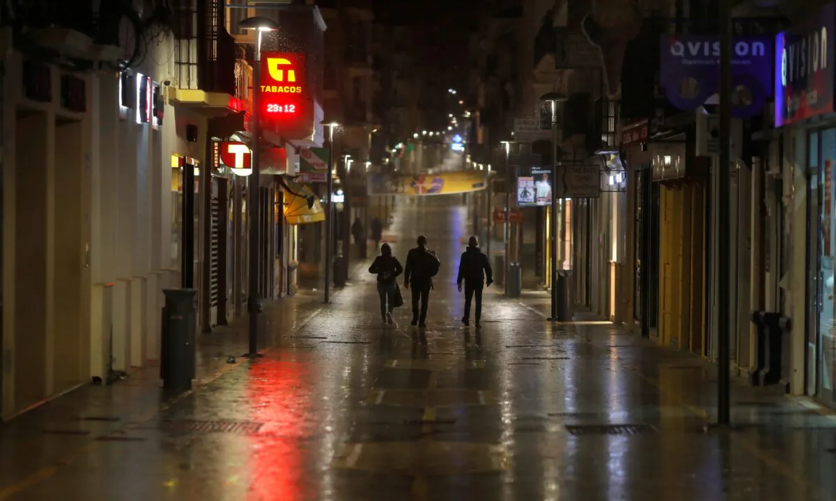 People walk along an empty street during the first day of the night-time curfew set as part of a state of emergency in an effort to control the outbreak of the coronavirus disease (COVID-19), in downtown Ronda, Spain, on Oct. 25, 2020. (Jon Nazca/Reuters)