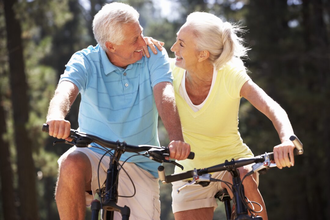A couple enjoys sunlight while riding bikes. (Monkey Business Images/Shutterstock)