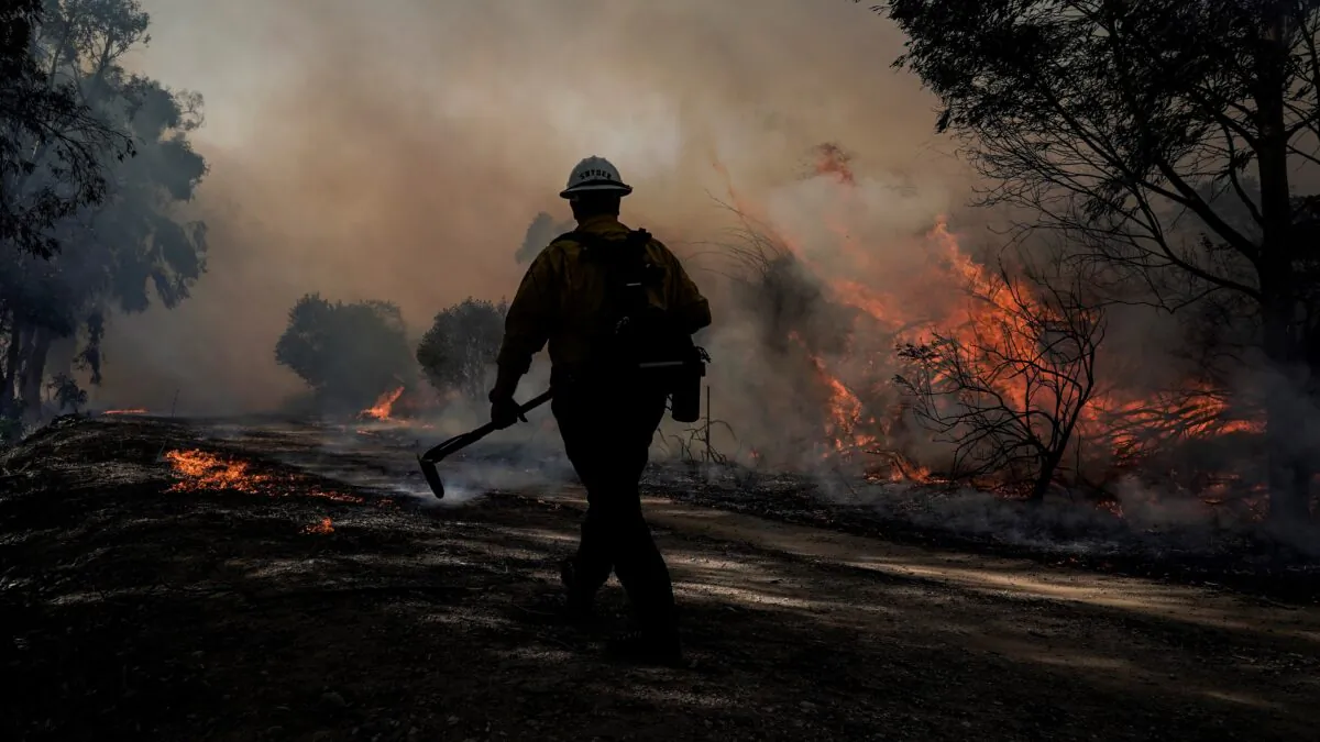 A firefighter prepares to put out hotspots while battling the Silverado Fire in Irvine, Calif., on Oct. 26, 2020. (Jae C. Hong/AP Photo)