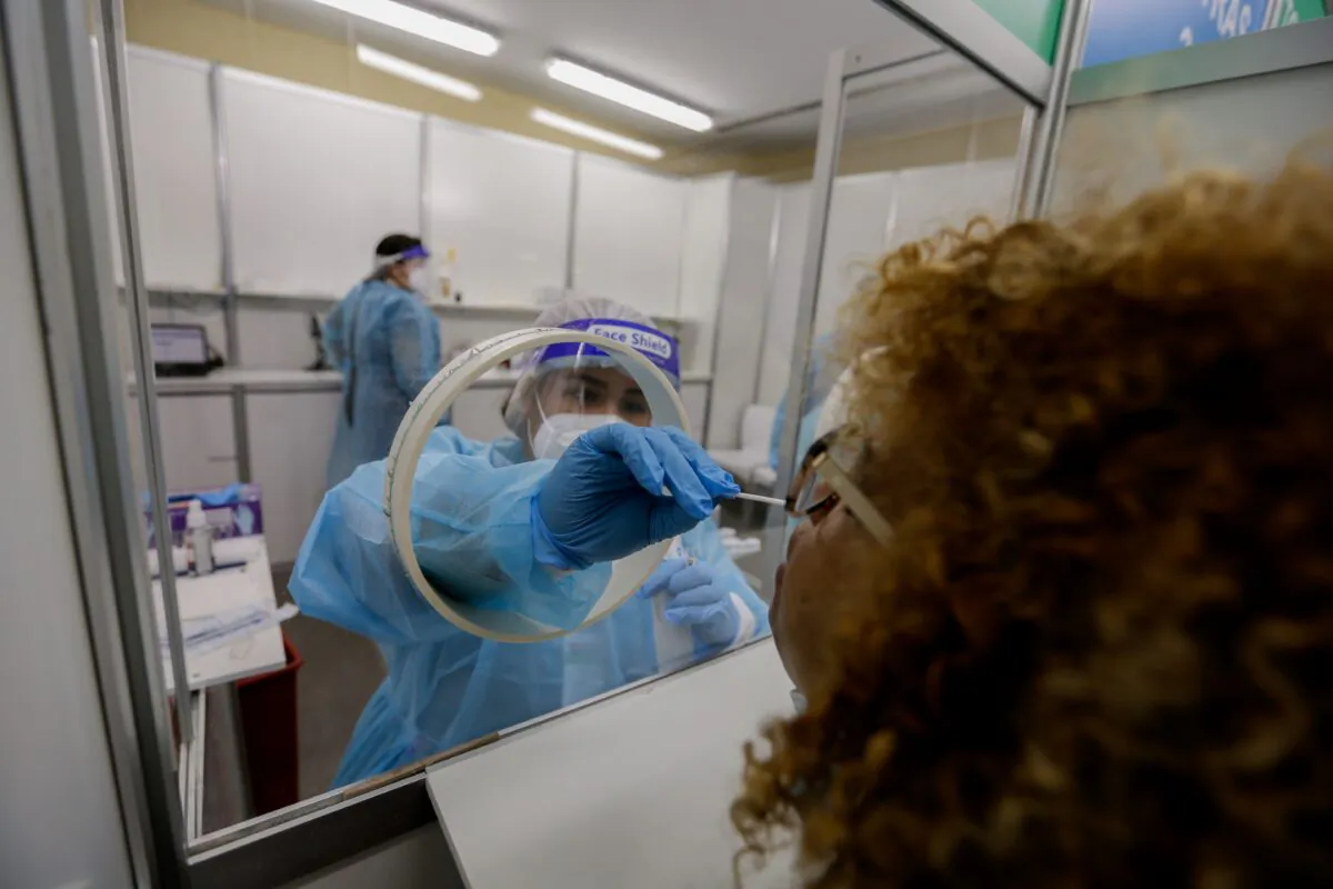 A health worker takes a swab sample from a woman at a rapid coronavirus testing station at Tocumen International Airport in Panama City on Oct. 12, 2020. (STR/AFP via Getty Images)