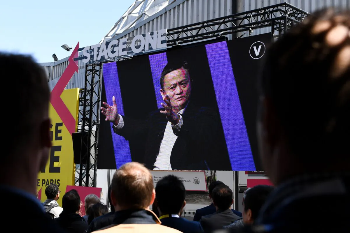 People watch a giant screen as Alibaba founder Jack Ma speaks during the VivaTech startups and innovation fair in Paris on May 16, 2019. (Alain Jocard/AFP via Getty Images)