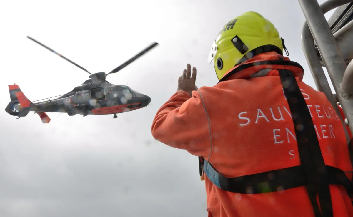 A French SNSM (Societe National de Sauvetage en Mer) lifeboat man waves to a helicopter of the French Navy during a rescue off the coast of Calais, France, on July 4, 2013. (Denis Charlot/AFP via Getty Images)