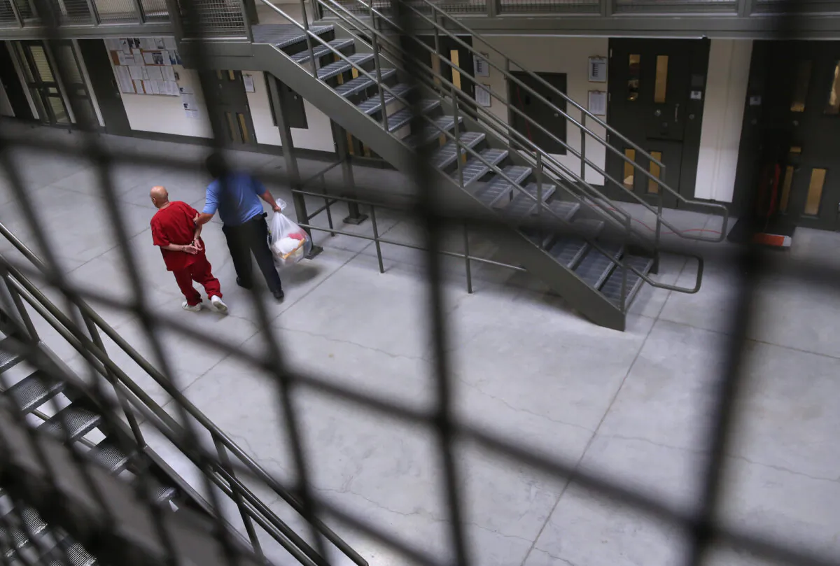 A guard escorts a detainee back into the general population at the Adelanto Detention Facility, in Adelanto, Calif., on Nov. 15, 2013. (John Moore/Getty Images)