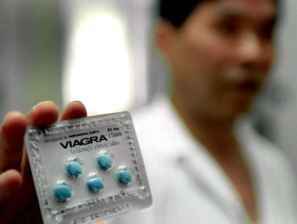 A Chinese doctor shows the anti-impotence drug Viagra at a hospital in Shanghai on July 5, 2000. (Liu Jin/AFP via Getty Images)