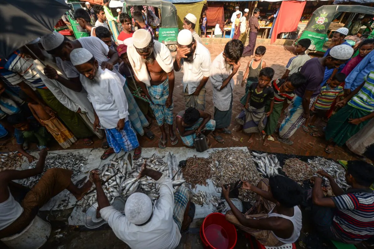 Rohingya refugees buy fish at a market place in Kutupalong refugee camp in Ukhia on Oct. 8, 2020. (Munir Uz zaman/AFP via Getty Images)