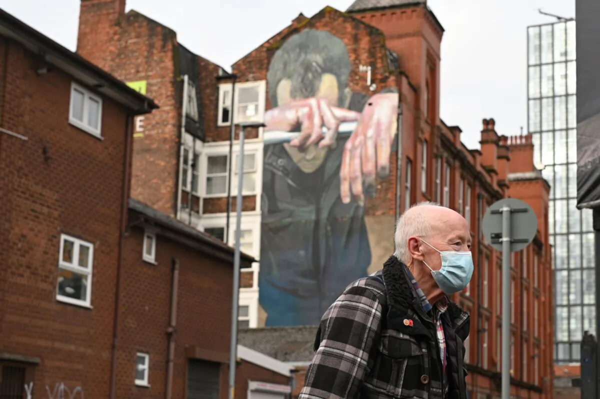 A man walks past a mural painted as part of the Cities of Hope festival in 2016 and highlighting mental health, in Ancoats, northern Manchester, England, on Oct. 16, 2020. (Oli Scarff/AFP via Getty Images)