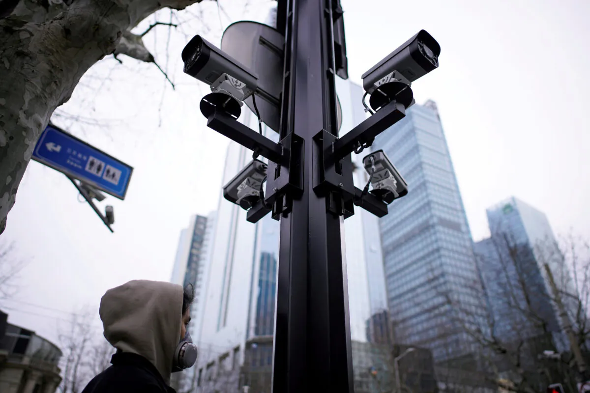 A man wearing a protective face mask walks under surveillance cameras as China is hit by an outbreak of the novel coronavirus, in Shanghai, China on March 4, 2020. (Aly Song/Reuters)