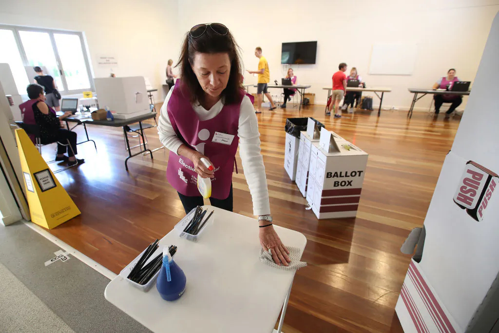 An election official sanitizes a table at a polling booth on March 28, 2020 in Brisbane, Australia. (Jono Searle/Getty Images)