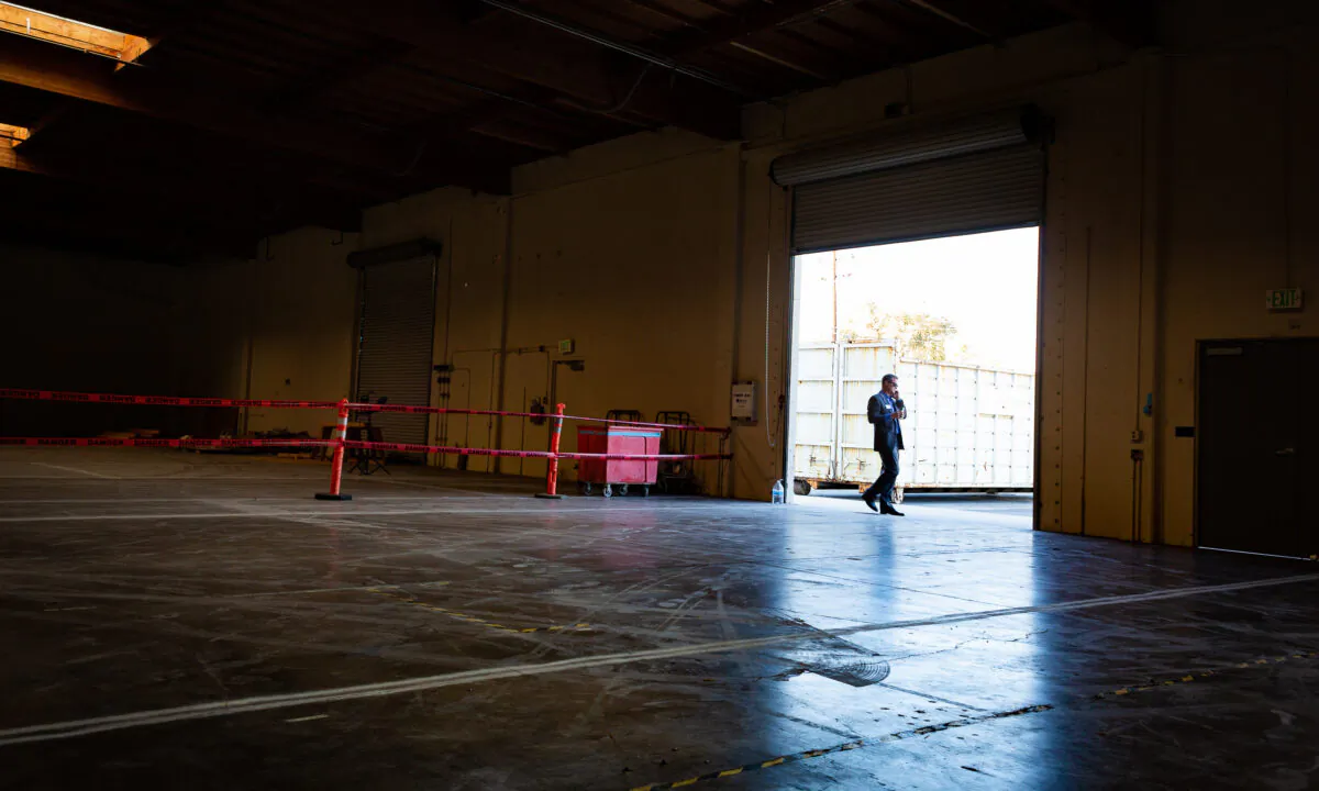 A man at the entrance of an industrial building that will be converted into a homeless shelter in Santa Ana, Calif., on Oct. 30, 2020. (John Fredricks/The Epoch Times)