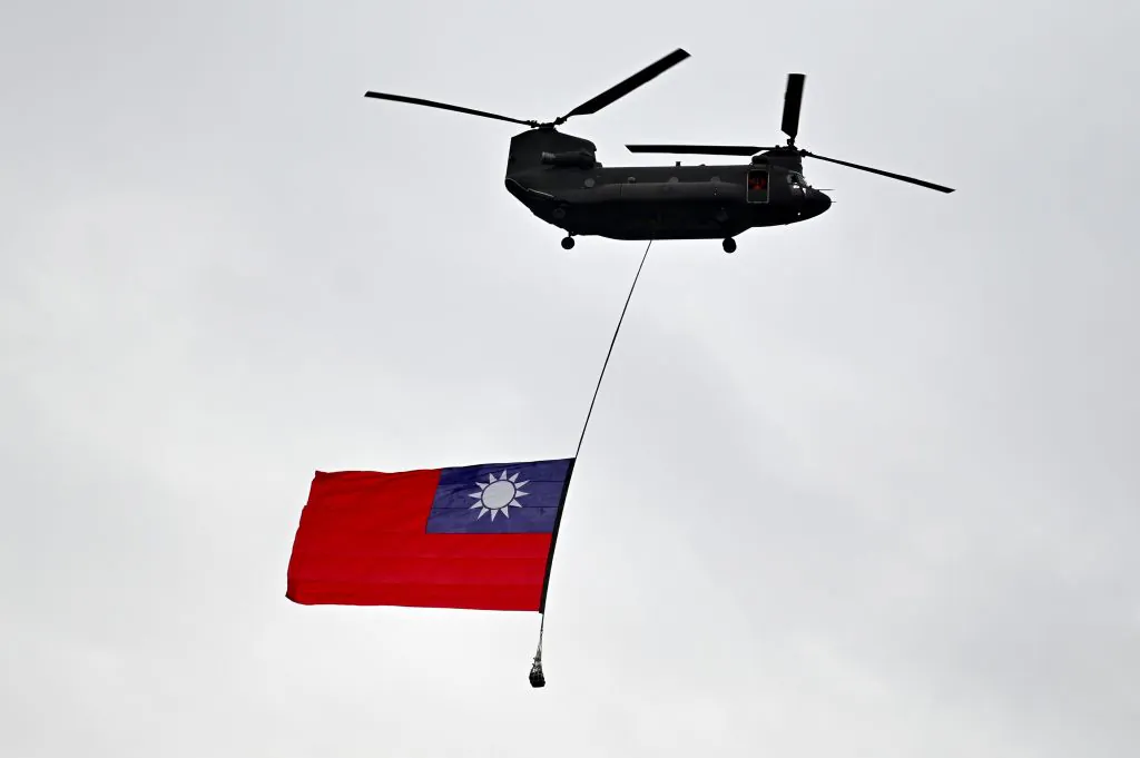 A military helicopter flies with Taiwan's national flag during the National Day in front of the Presidential Office in Taipei on Oct. 10, 2020. (Sam Yeh/AFP via Getty Images) 
