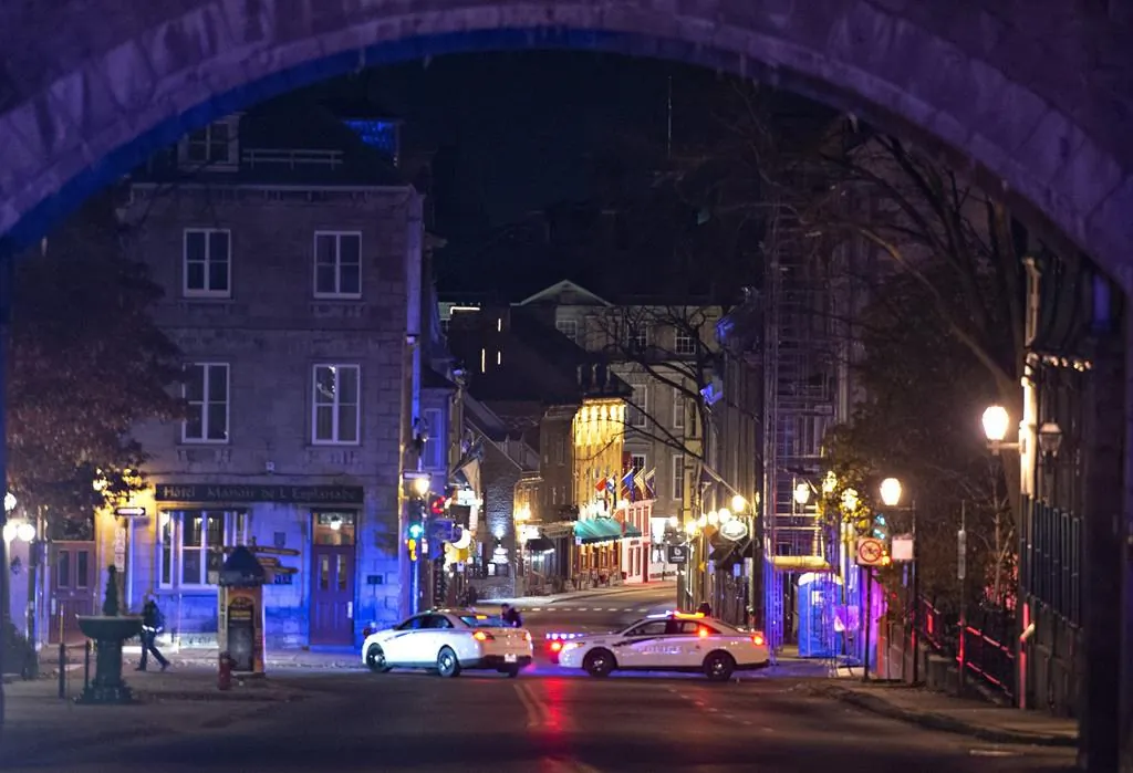 Police cars block the Saint-Louis Street near the Chateau Frontenac, on Nov. 1, 2020 in Quebec City. A man wearing medieval clothed was arrested. Two people are dead and five people were injured after they were stabbed. (The Canadian Press/Jacques Boissinot)
