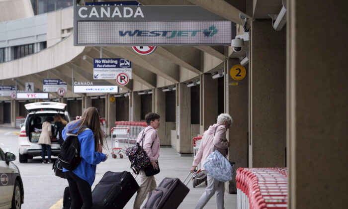 Travellers arrive at the Calgary Airport in Alberta on May 10, 2018. (Jeff McIntosh/The Canadian Press)