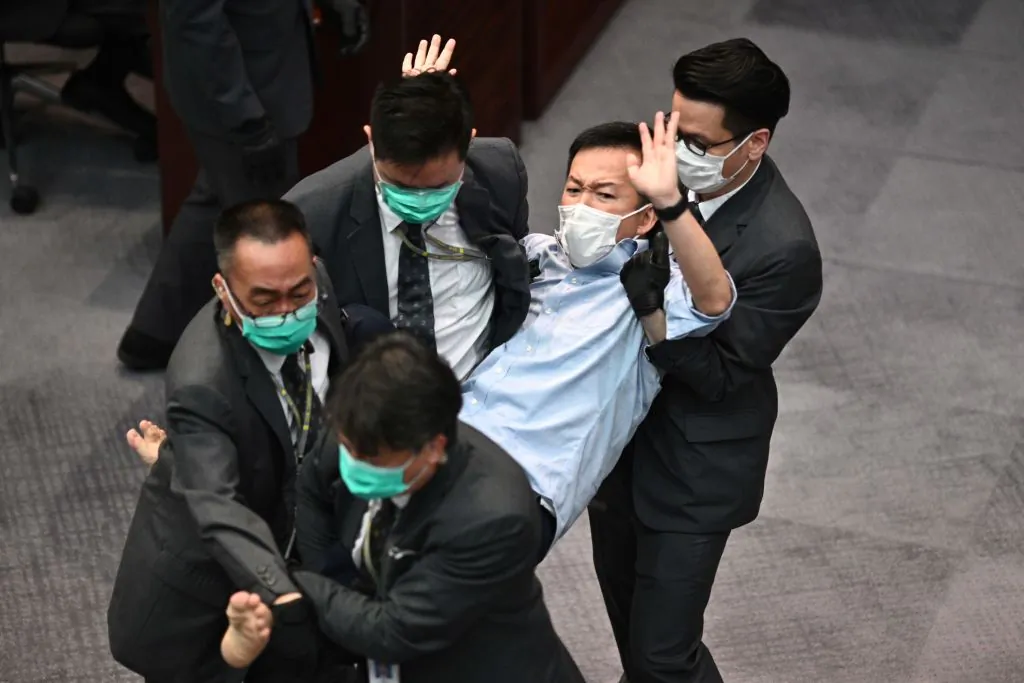 Pro-democracy lawmaker Raymond Chan (C) is carried away by security following scuffles at the Legislative Council (LegCo) in Hong Kong on May 8, 2020. (Anthony Wallace/AFP via Getty Images)