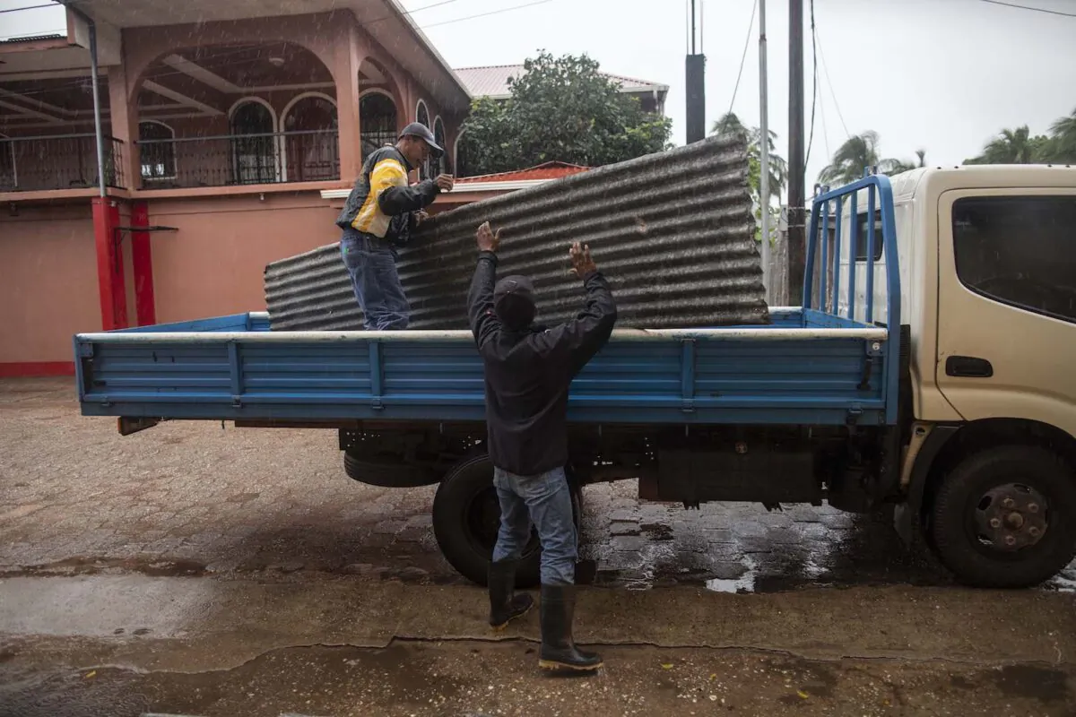 Workers carry zinc sheets to protect windows before the arrival of Hurricane Eta, in Bilwi, Puerto Cabezas, Nicaragua, on Nov. 2, 2020. (Inti Ocon/AFP via Getty Images)